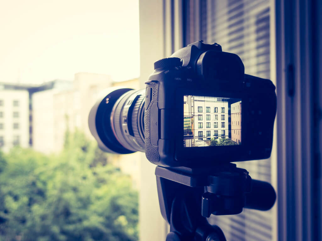 włączony aparat fotograficzny ustawiony w oknie mieszkania