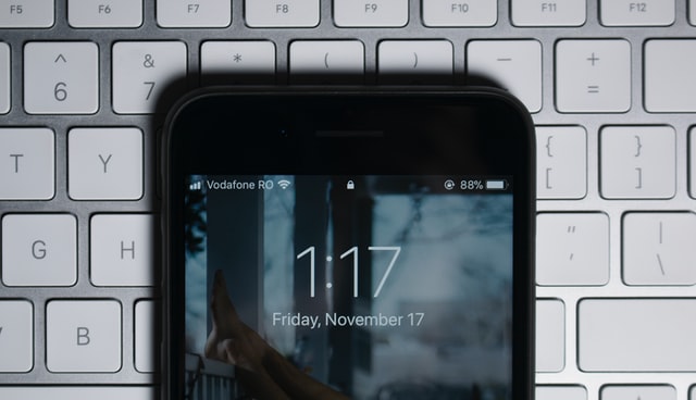 zbliżenie na zegar w telefonie leżący na klawiaturze