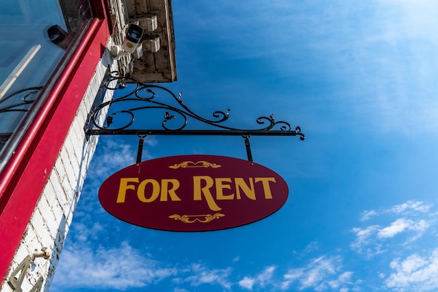 znak "For Rent" na tle niebieskiego nieba
